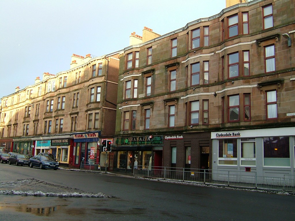 Row of traditional red and blond sandstone tenement buildings on a Glasgow street